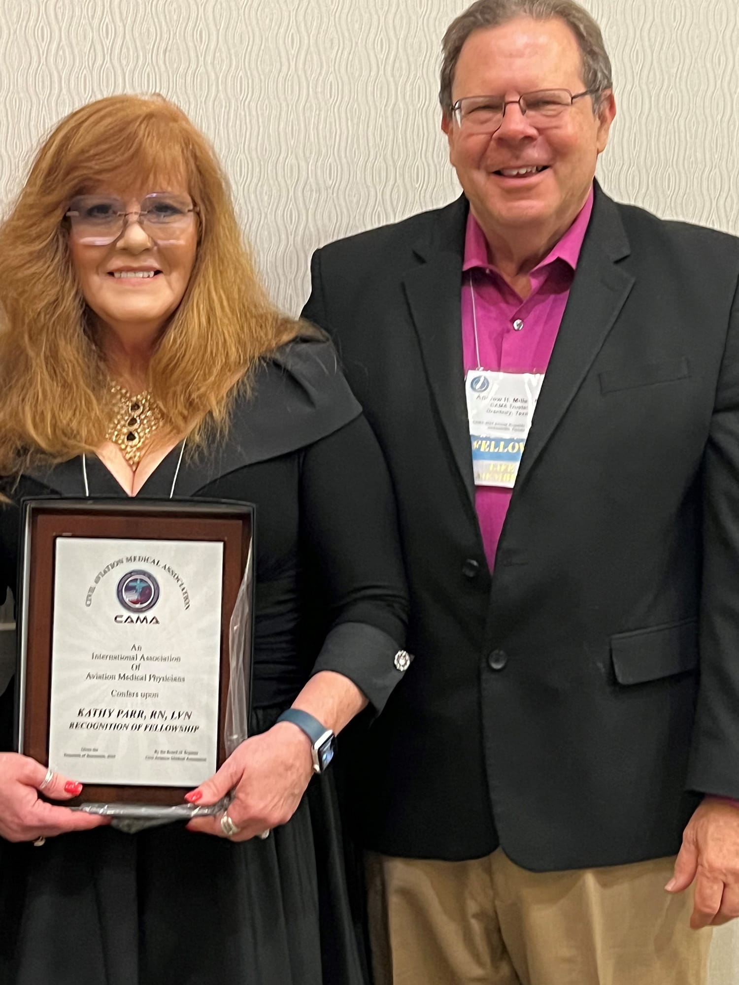 a nurse with a plaque next to a doctor