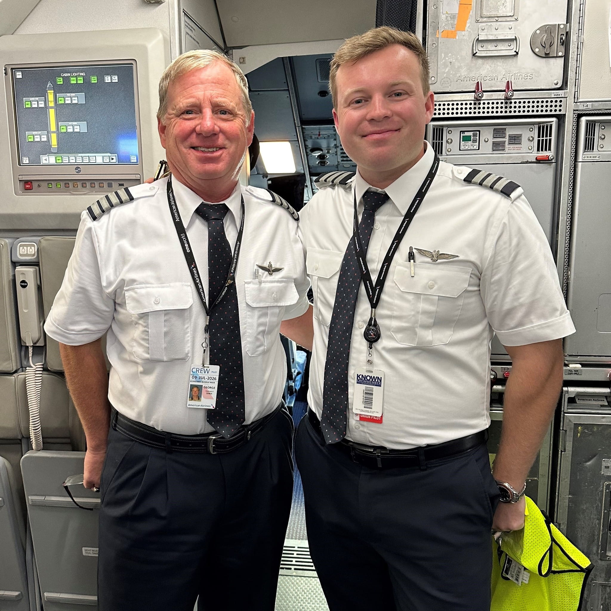 two smiling pilots outside a cockpit