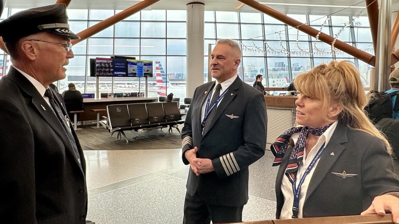 three pilots talking at an airport